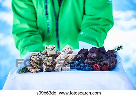 Mid section of male skier carrying tray of cake and berries, Aspen, Colorado, USA View Large Photo Image Picture - Mid section of male skier carrying tray of cake and berries, Aspen, Colorado, USA. Fotosearch