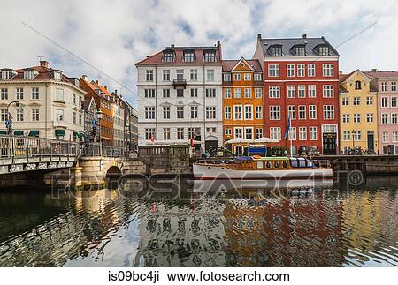 Moored boat and bridge with colourful 17th century town houses on Nyhavn canal, Copenhagen, Denmark View Large Photo Image Stock Image - Moored boat and bridge with colourful 17th century town houses on Nyhavn canal, Copenhagen, Denmark. Fotosearch