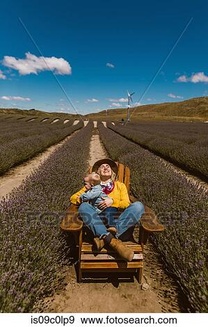 Stock Photo - Mother and baby relaxing in meadow, Wanaka, Taranaki, New Zealand. Fotosearch
