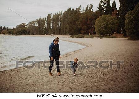 Mother and baby walking on beach, Wanaka, Taranaki, New Zealand View Large Photo Image Picture - Mother and baby walking on beach, Wanaka, Taranaki, New Zealand. Fotosearch