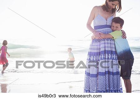 Stock Image - Mother and children on beach, Cape Town, South Africa. Fotosearch