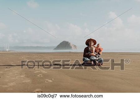 Stock Photo - Mother and children sitting on beach, Morro Bay, California, United States. Fotosearch