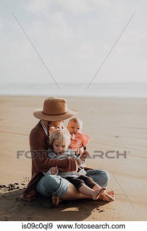 Mother and children sitting on beach View Large Photo Image Stock Photo - Mother and children sitting on beach. Fotosearch