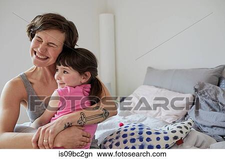 Picture - Mother and daughter at home, hugging. Fotosearch