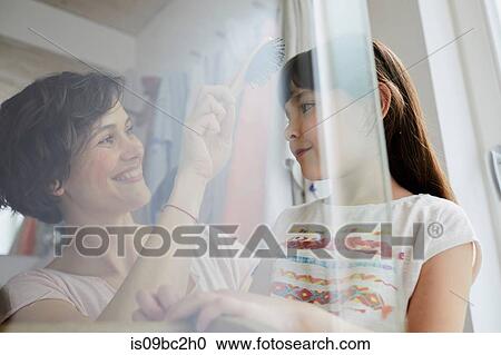 Mother and daughter at home, mother brushing daughter's hair View Large Photo Image Stock Image - Mother and daughter at home, mother brushing daughter's hair. Fotosearch