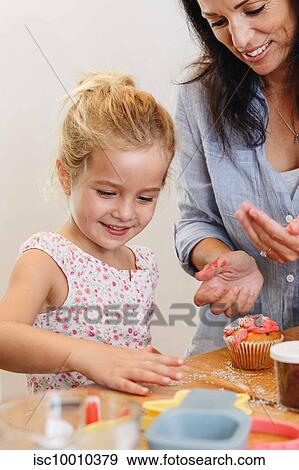 Mother and daughter decorating cupcake with frosting in kitchen View Large Photo Image Stock Photo - Mother and daughter decorating cupcake with frosting in kitchen. Fotosearch