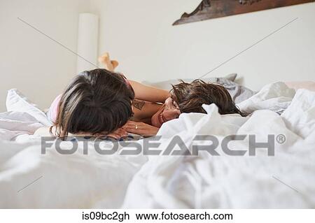 Mother and daughter lying on bed, face to face, smiling View Large Photo Image Stock Image - Mother and daughter lying on bed, face to face, smiling. Fotosearch
