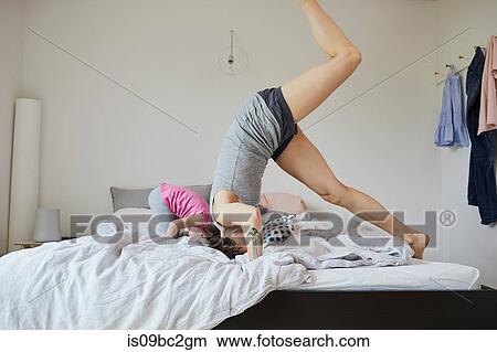Mother and daughter playing in bedroom, doing headstands View Large Photo Image Picture - Mother and daughter playing in bedroom, doing headstands. Fotosearch