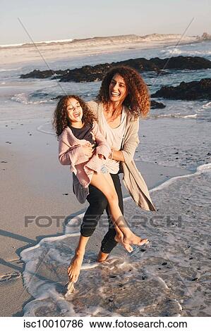 Mother and daughter playing on beach View Large Photo Image Stock Photograph - Mother and daughter playing on beach. Fotosearch