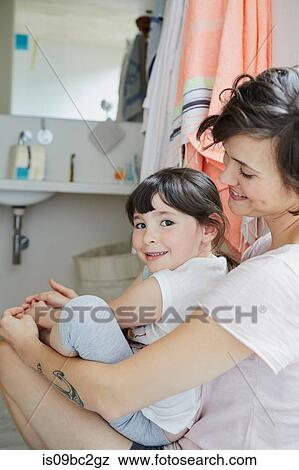 Mother and daughter sitting together in bathroom, smiling View Large Photo Image Stock Photo - Mother and daughter sitting together in bathroom, smiling. Fotosearch