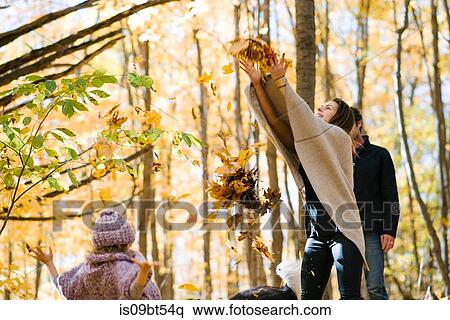 Mother and daughter throwing autumn leaves in air in forest View Large Photo Image Stock Photography - Mother and daughter throwing autumn leaves in air in forest. Fotosearch