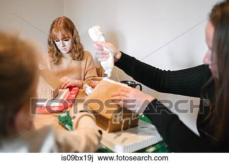 Mother and daughters decorating gingerbread house for Christmas View Large Photo Image Stock Image - Mother and daughters decorating gingerbread house for Christmas. Fotosearch