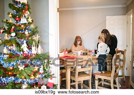 Stock Image - Mother and daughters preparing for Christmas. Fotosearch
