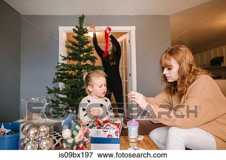 Stock Photo - Mother and daughters preparing for Christmas. Fotosearch