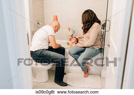 Mother and father playing with baby daughter in bath View Large Photo Image Stock Photograph - Mother and father playing with baby daughter in bath. Fotosearch
