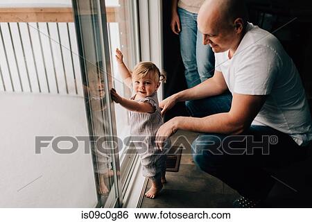 Mother and father with baby daughter at patio door View Large Photo Image Stock Photograph - Mother and father with baby daughter at patio door. Fotosearch