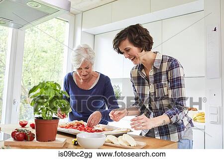 Mother and grown daughter at home, preparing food together View Large Photo Image Stock Image - Mother and grown daughter at home, preparing food together. Fotosearch