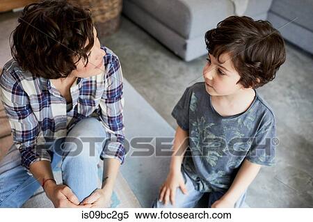 Mother and son at home, sitting on floor, talking View Large Photo Image Stock Photography - Mother and son at home, sitting on floor, talking. Fotosearch