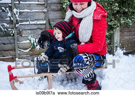 Mother and son in snow on toboggan View Large Photo Image Stock Image - Mother and son in snow on toboggan. Fotosearch