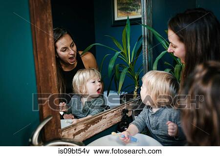 Mother and son looking into mirror with open mouth View Large Photo Image Stock Photo - Mother and son looking into mirror with open mouth. Fotosearch