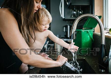 Mother and son washing plate in kitchen sink View Large Photo Image Stock Image - Mother and son washing plate in kitchen sink. Fotosearch