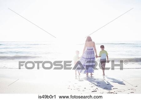 Stock Image - Mother and sons on beach, Cape Town, South Africa. Fotosearch