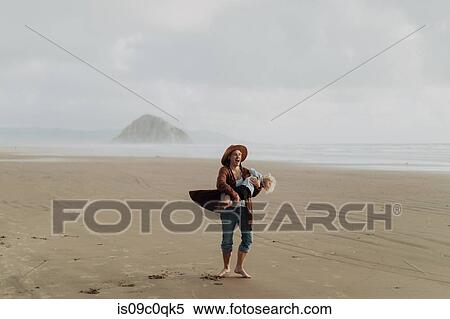 Stock Photography - Mother and toddler playing with sand on beach, Morro Bay, California, United States. Fotosearch