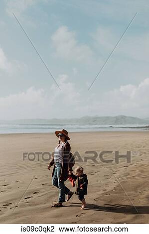 Stock Image - Mother and toddler walking on beach, Morro Bay, California, United States. Fotosearch