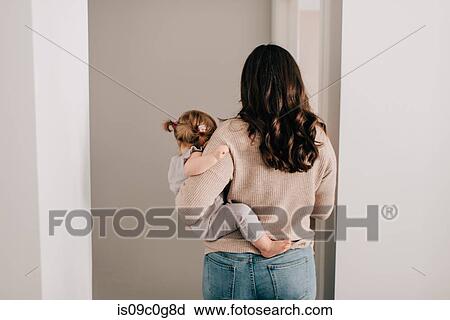 Mother carrying baby daughter through hall doorway, rear view View Large Photo Image Stock Image - Mother carrying baby daughter through hall doorway, rear view. Fotosearch