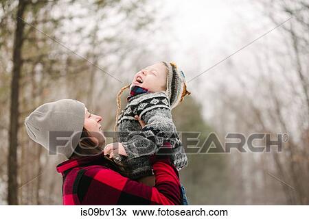 Stock Photo - Mother carrying up son in forest. Fotosearch