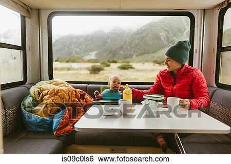 Stock Photograph - Mother feeding baby in motorhome, Wanaka, Taranaki, New Zealand. Fotosearch