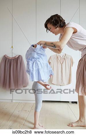 Mother helping daughter to dress View Large Photo Image Stock Photo - Mother helping daughter to dress. Fotosearch