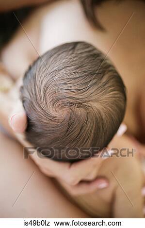 Stock Photo - Mother holding newborn baby boy, mid section, close-up. Fotosearch