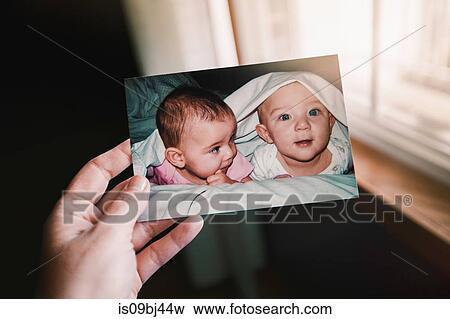 Mother holding photograph of twin baby girl and boy, close up of hand, personal perspective View Large Photo Image Stock Photo - Mother holding photograph of twin baby girl and boy, close up of hand, personal perspective. Fotosearch