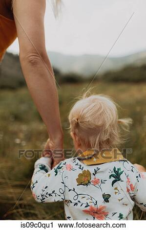 Stock Image - Mother holding toddler daughter's hand in rural valley, cropped rear view, Mineral King, California, USA. Fotosearch