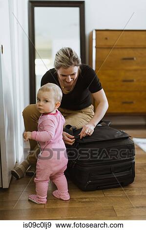 Mother on luggage with baby in bedroom View Large Photo Image Stock Photo - Mother on luggage with baby in bedroom. Fotosearch