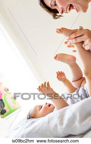 Mother playing with baby daughter, laughing View Large Photo Image Picture - Mother playing with baby daughter, laughing. Fotosearch