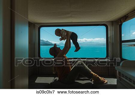 Stock Photo - Mother playing with baby in motorhome, Wanaka, Taranaki, New Zealand. Fotosearch