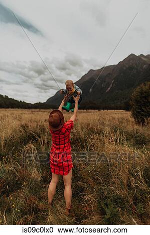 Stock Image - Mother playing with baby in wilderness, Queenstown, Canterbury, New Zealand. Fotosearch
