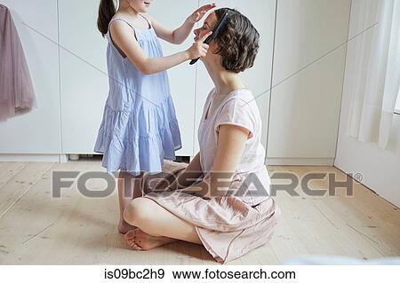 Mother sitting on floor, daughter brushing mother's hair, mid section View Large Photo Image Stock Photo - Mother sitting on floor, daughter brushing mother's hair, mid section. Fotosearch
