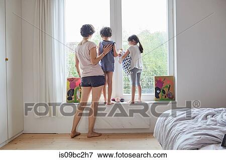 Mother, son and daughter looking out of bedroom window, rear view View Large Photo Image Stock Photo - Mother, son and daughter looking out of bedroom window, rear view. Fotosearch