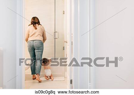 Stock Photography - Mother with baby daughter preparing bath, rear view. Fotosearch
