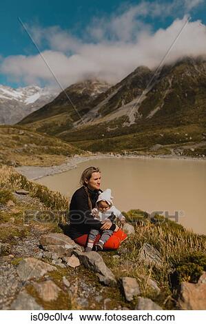 Mother with baby enjoying scenic view by lake, Wanaka, Taranaki, New Zealand View Large Photo Image Picture - Mother with baby enjoying scenic view by lake, Wanaka, Taranaki, New Zealand. Fotosearch