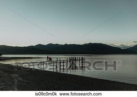 Stock Image - Mother with baby in pram walking on pier, Queenstown, Canterbury, New Zealand. Fotosearch
