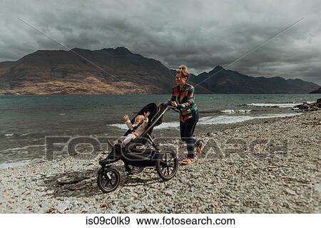Mother with baby in pram walking on beach, Queenstown, Canterbury, New Zealand View Large Photo Image Stock Photo - Mother with baby in pram walking on beach, Queenstown, Canterbury, New Zealand. Fotosearch