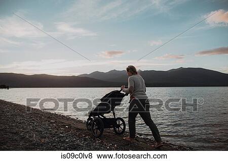 Mother with baby in pram walking on beach, Te Anau, Southland, New Zealand View Large Photo Image Stock Photo - Mother with baby in pram walking on beach, Te Anau, Southland, New Zealand. Fotosearch