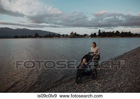 Mother with baby in pram walking on beach, Te Anau, Southland, New Zealand View Large Photo Image Stock Photo - Mother with baby in pram walking on beach, Te Anau, Southland, New Zealand. Fotosearch