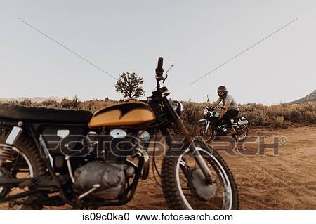 Motorbiker passing stationary motorbike, Kennedy Meadows, California, US View Large Photo Image Stock Image - Motorbiker passing stationary motorbike, Kennedy Meadows, California, US. Fotosearch