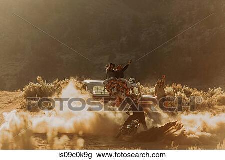 Motorbiker raising dust, friends cheering on in background, Kennedy Meadows, California, US View Large Photo Image Stock Image - Motorbiker raising dust, friends cheering on in background, Kennedy Meadows, California, US. Fotosearch