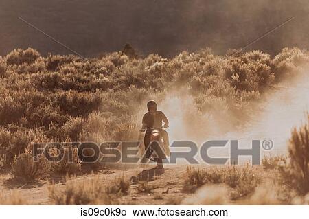 Picture - Motorbiker raising dust, Kennedy Meadows, California, US. Fotosearch